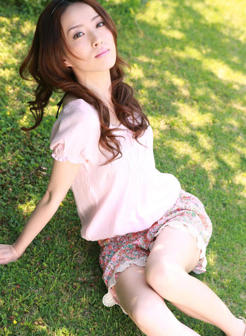 坐在绿草地上的日本美女盗摄写真图片