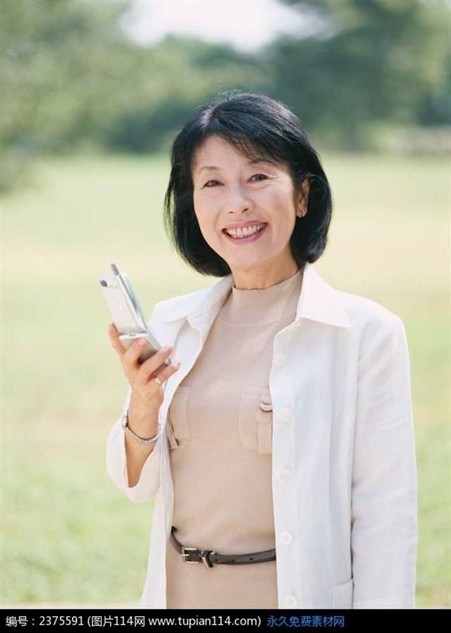 草地上拿着电话的中年女人(点击浏览下一张趣图)