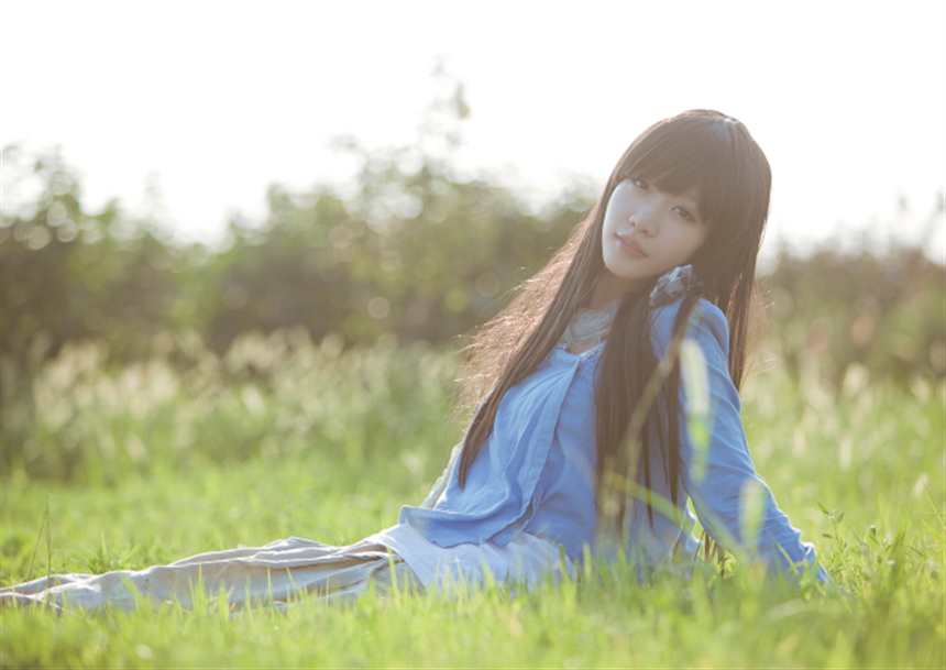 躺坐在草地中的女孩,长焦镜头营造了浅景深,画面清新自然(点击浏览下一张趣图)
