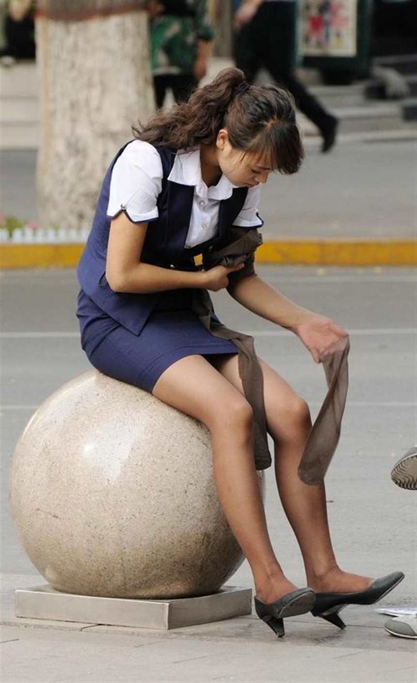 街拍: 穿着制服的美女, 坐在石球上研究刚买的丝袜(点击浏览下一张趣图)
