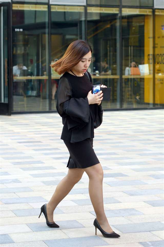 蓝月帝国街拍:拿着两个手机的黑丝袜美女