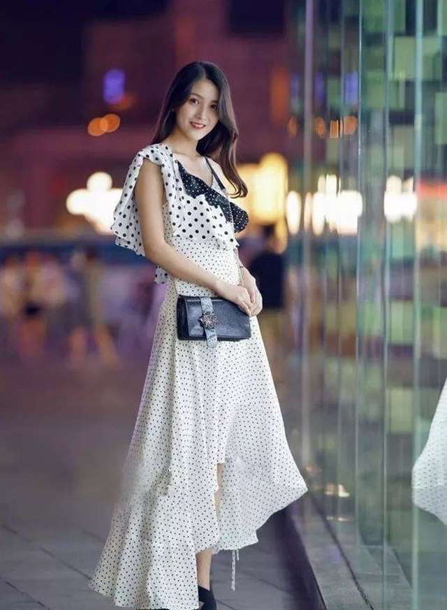 街拍:少妇身穿抹茶色的t恤,搭配黑色的短裤,秀出雪白的长腿