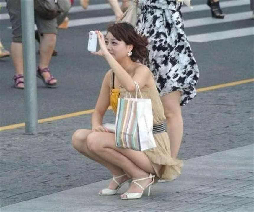 街拍:路边少妇忘情拍摄,只是短裙太短没留意露点了