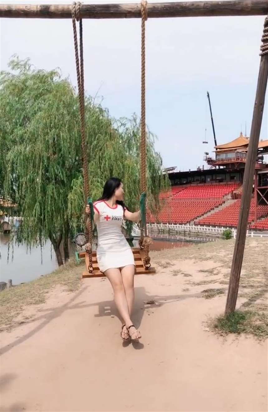 穿着包臀裙荡秋千的美少妇,尽显成熟女性身姿