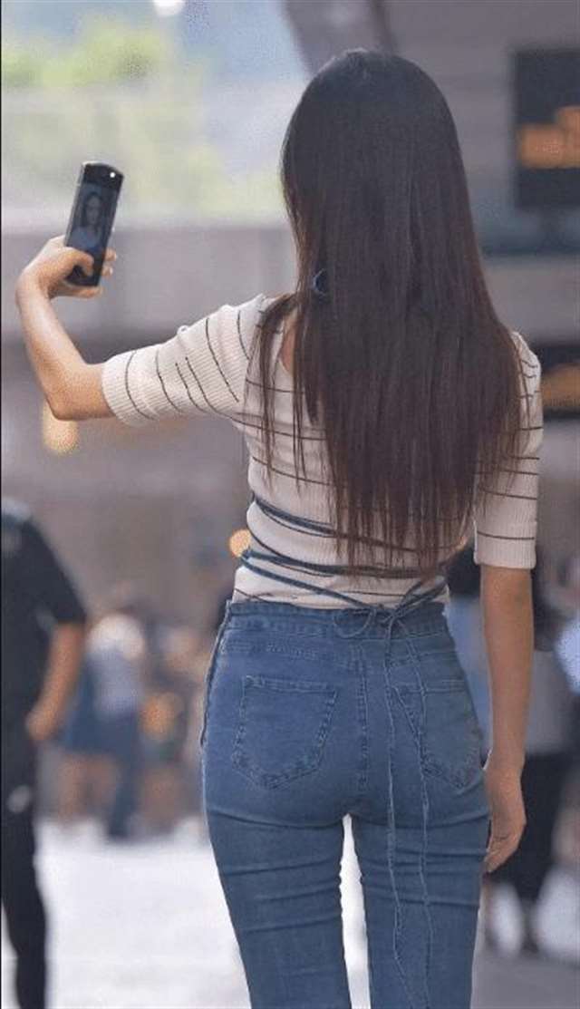 少妇与紧身牛仔裤美女搭配上吊带上衣轻松展示出傲人的臀围