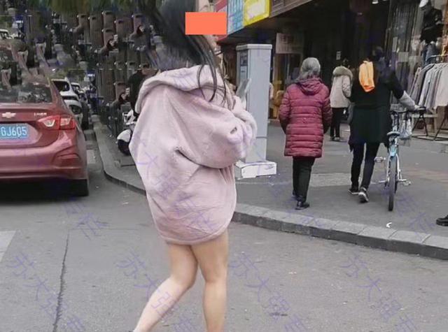 江苏女子光着腿出门全身只穿一件外套拿着手机左顾右盼