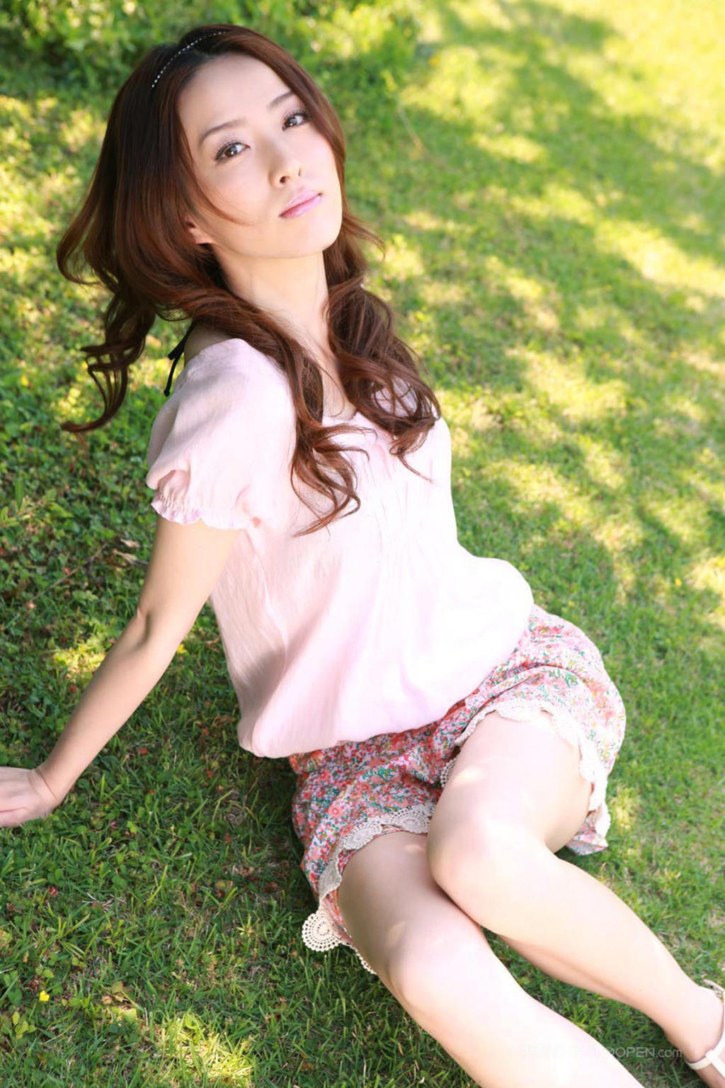 坐在绿草地上的日本美女盗摄写真图片